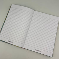 Open notebook with lined pages on a light gray background