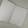 Open notebook with dot grid pages on a plain background