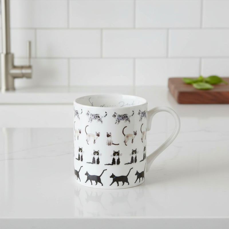 White mug with black and gray cat illustrations on a white background