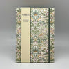 Notebook with floral pattern and Morris & Co branding on a gray background