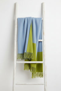 Blue and green throw blanket with fringes on a white background
