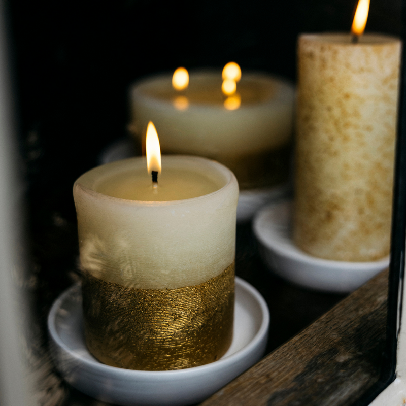 Decorative candles with gold and white layers on a dark background