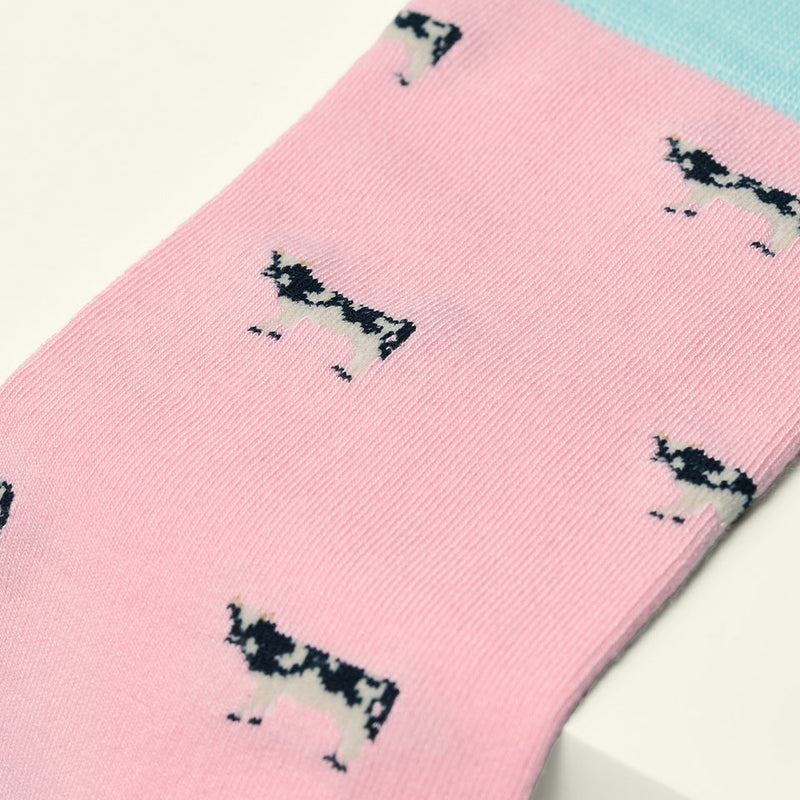 Pink sock with black and white cow pattern on a white background
