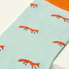 Light blue sock with orange fox pattern on a white background
