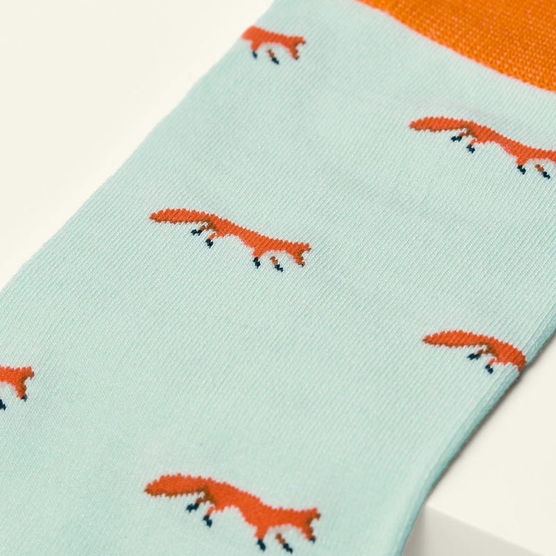 Light blue sock with orange fox pattern on a white background