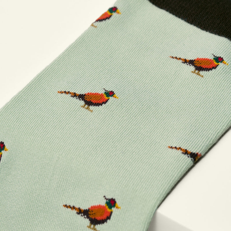 Light green sock with pheasant pattern on a white background