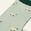Green sock with sheep pattern on a white background