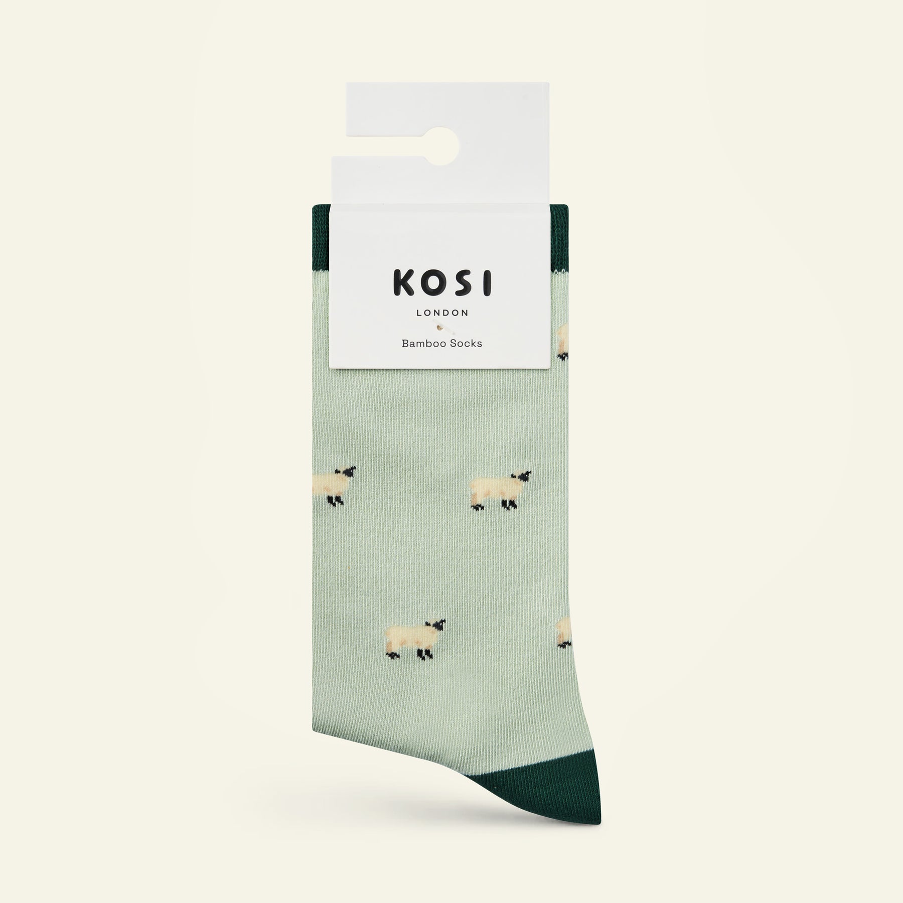 Green sock with sheep pattern and KOSI London packaging on a white background