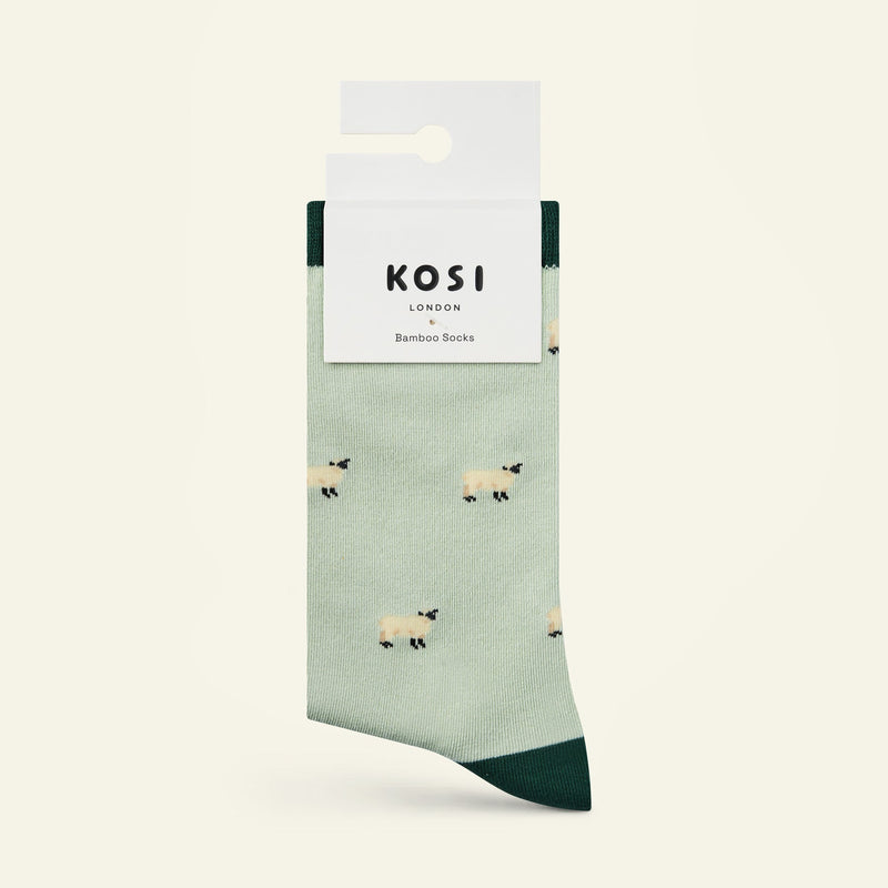 Green sock with sheep pattern and KOSI London packaging on a white background