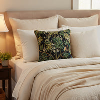 Decorative pillow with nature-themed pattern featuring leaves, flowers, and birds on a black background.