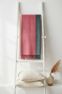 A rectangular woven throw with fringe, featuring three vertical color-blocked panels: a wide dusty rose center, a narrow beige stripe on the left, and a dark charcoal gray stripe on the right.