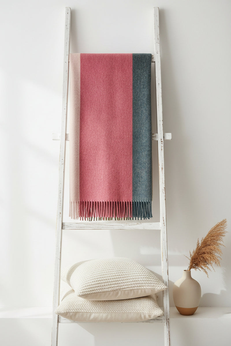 A rectangular woven throw with fringe, featuring three vertical color-blocked panels: a wide dusty rose center, a narrow beige stripe on the left, and a dark charcoal gray stripe on the right.