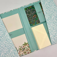 Set of stationery items including notebooks and an envelope with floral patterns and 'Morris & Co' branding.