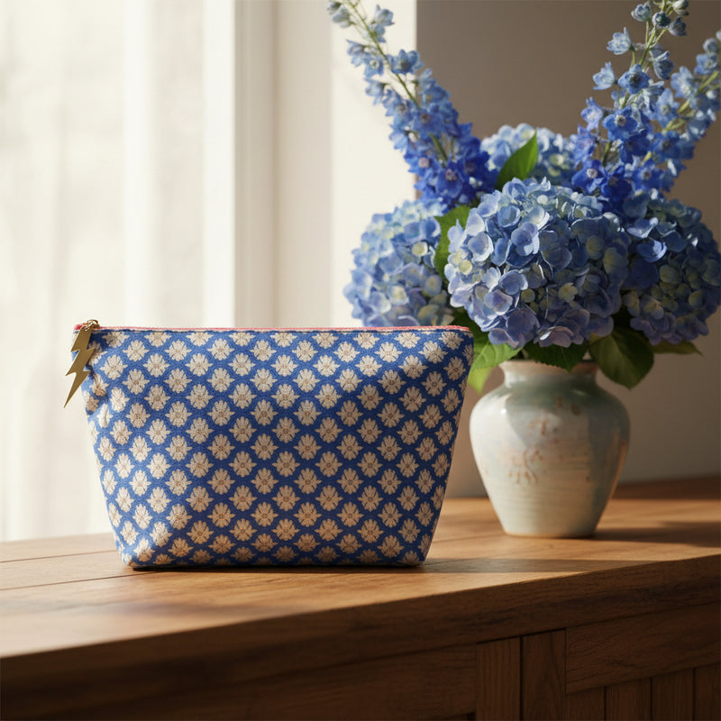 Blue pouch with white floral pattern on a white background